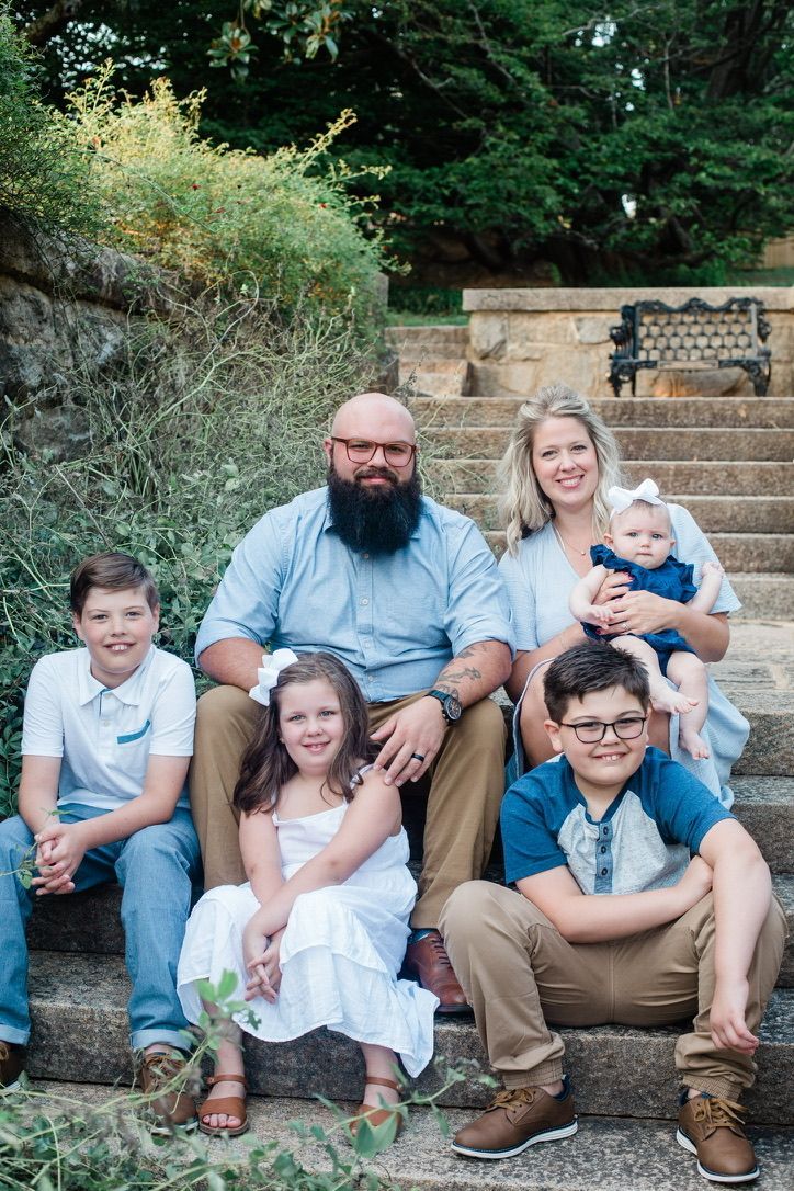 A family is posing for a picture on a set of stairs.