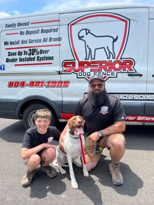 A woman is kneeling down next to a dog wearing a harness.