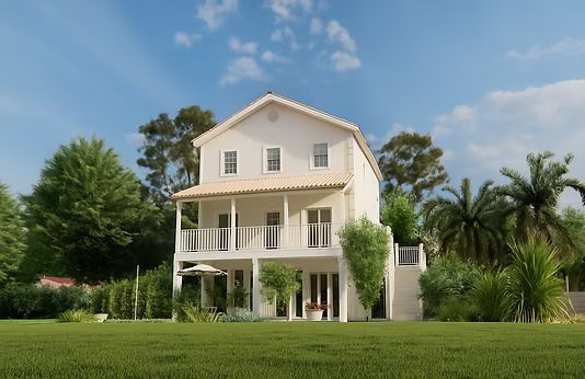 White two-story house with porch and balcony on a green lawn, surrounded by trees under a blue sky