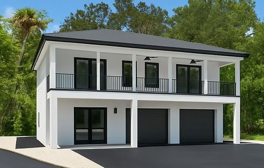 Modern two-story white house with balcony, black railings, and garage doors surrounded by trees