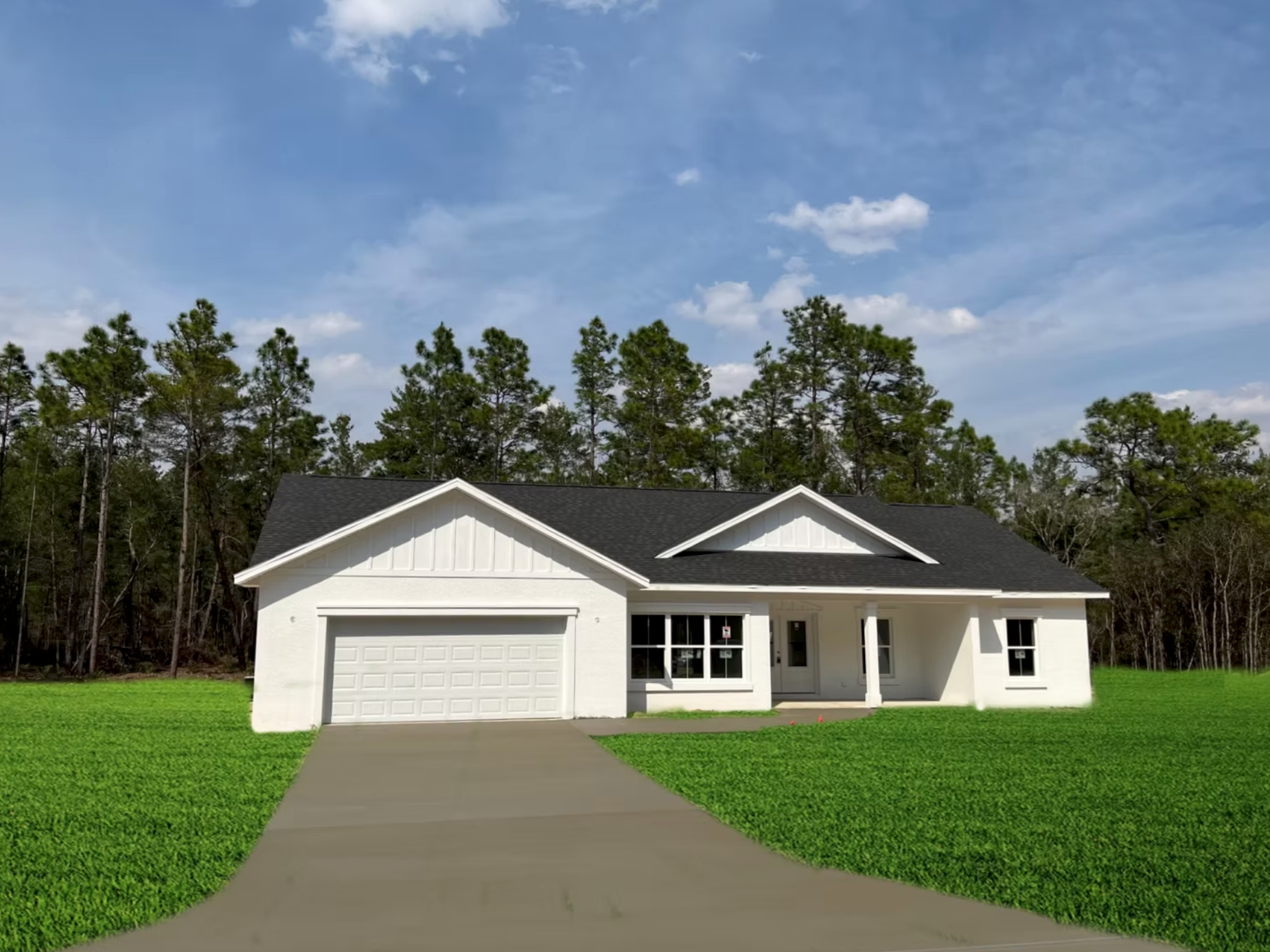 Single-story white house with gray roof, attached garage, and front porch beside a green lawn and trees