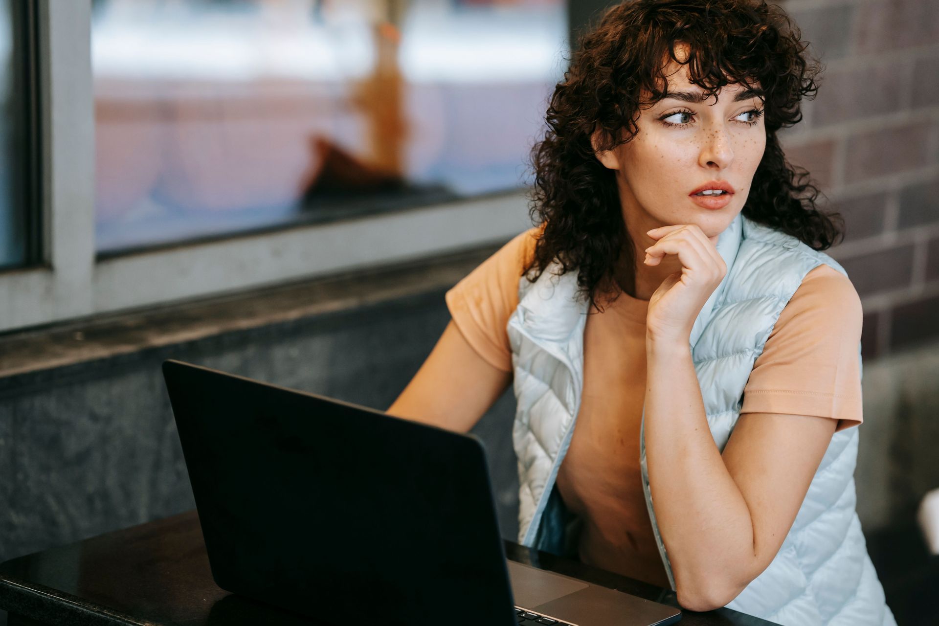 Femme pensive devant son ordinateur, s'interrogeant sur l'IA et son métier