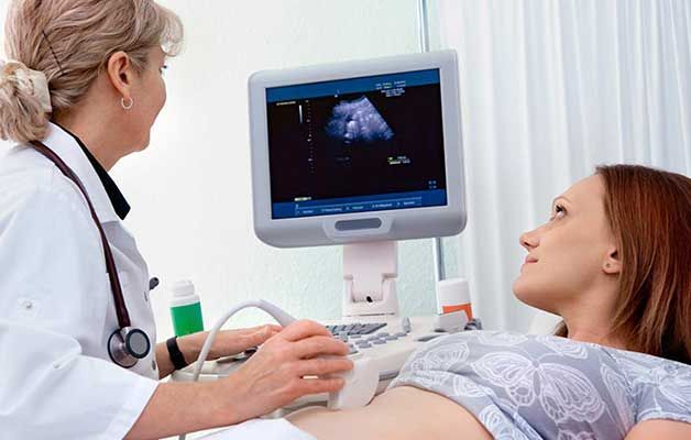 Una mujer embarazada está recibiendo una ecografía de un médico.