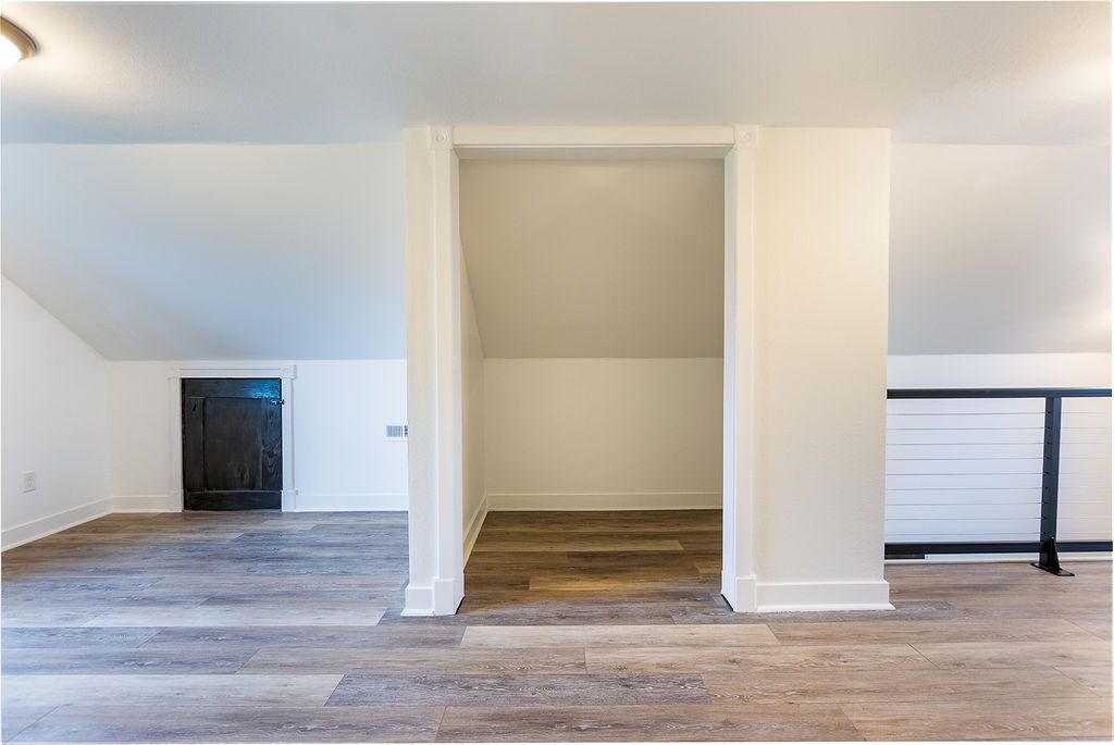 Interior of a room with slanted ceilings, wooden floor, and a built-in storage area.