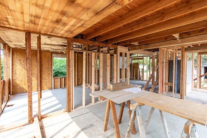 Interior view of a building under construction, showing wooden framing and exposed beams.
