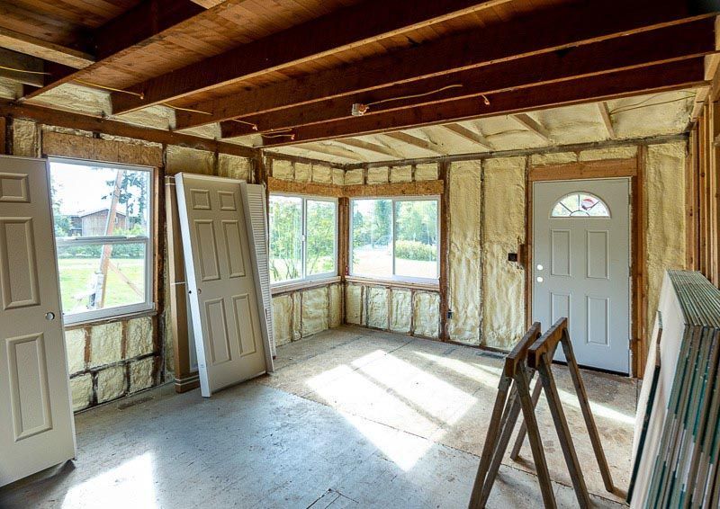 Interior room with exposed wood beams, spray foam insulation, and doors.