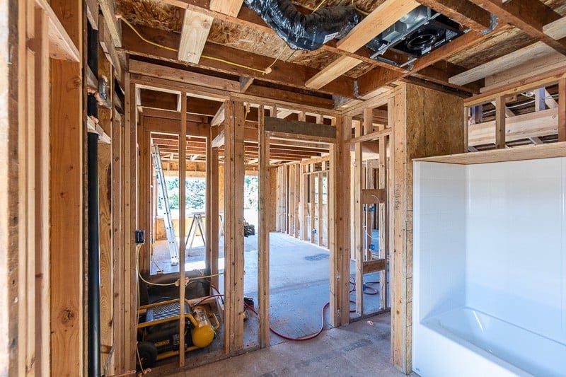 Interior of a building under construction, showing wooden framing and exposed structure.