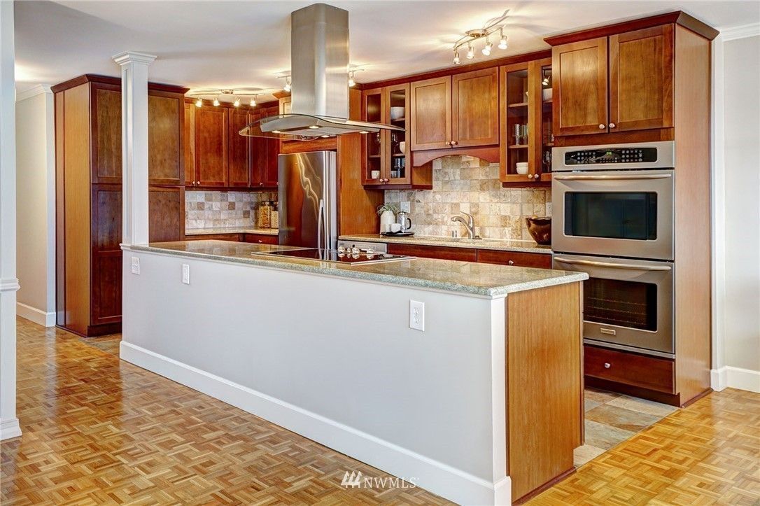 Kitchen with cherry wood cabinets, stainless steel appliances, and white countertop.