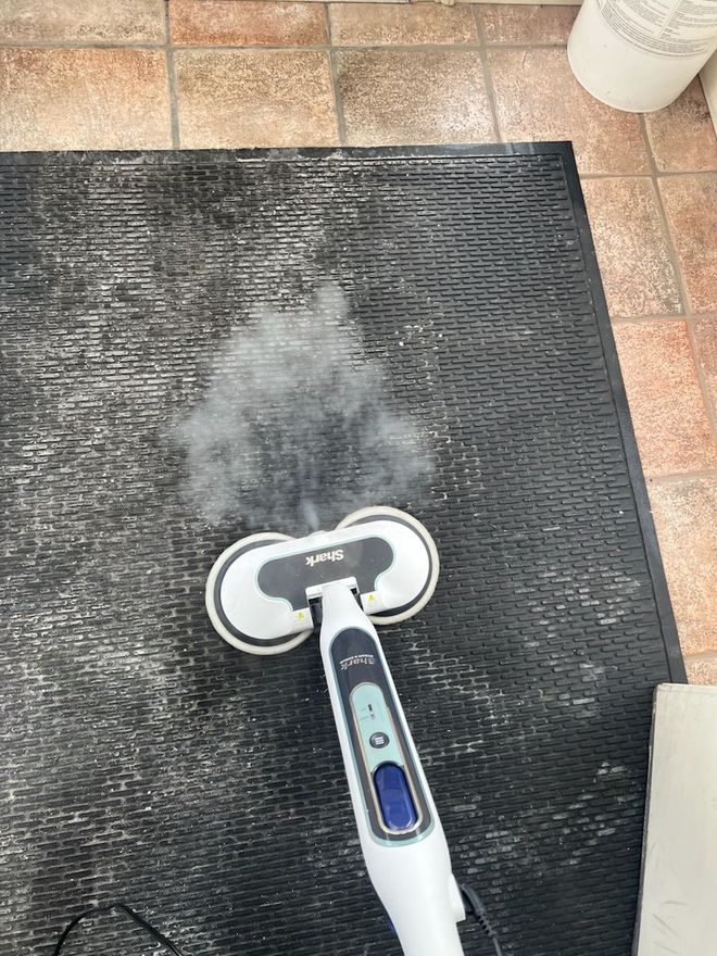 Floor scrubber cleaning a wet indoor floor in a hallway