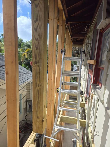 Interior room renovation with ladder, fireplace, window, and construction materials.