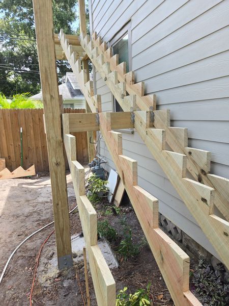 Wooden outdoor staircase built against a house.
