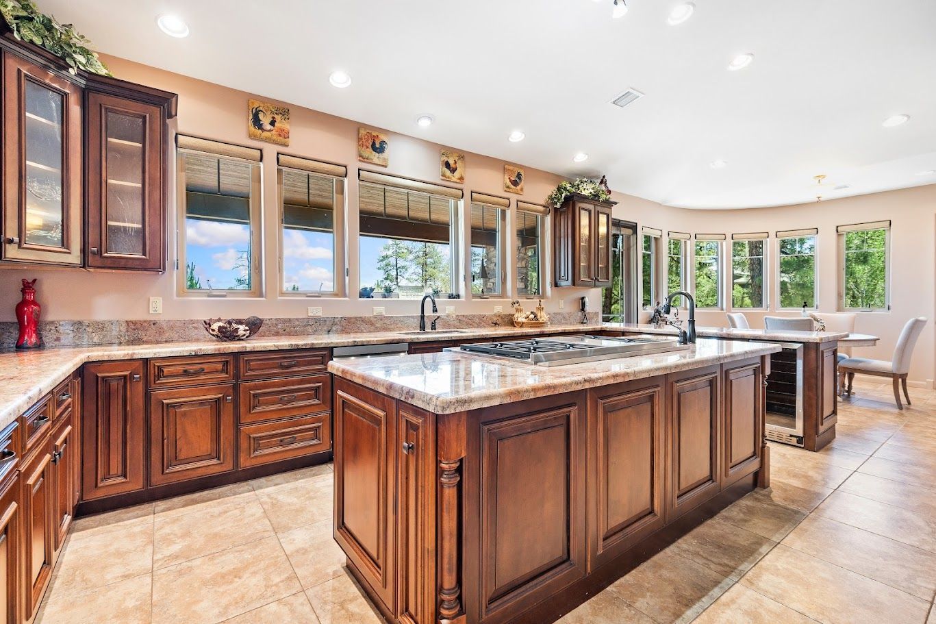 Elegant kitchen with white cabinets, blue island, gold accents, and stainless steel appliances.