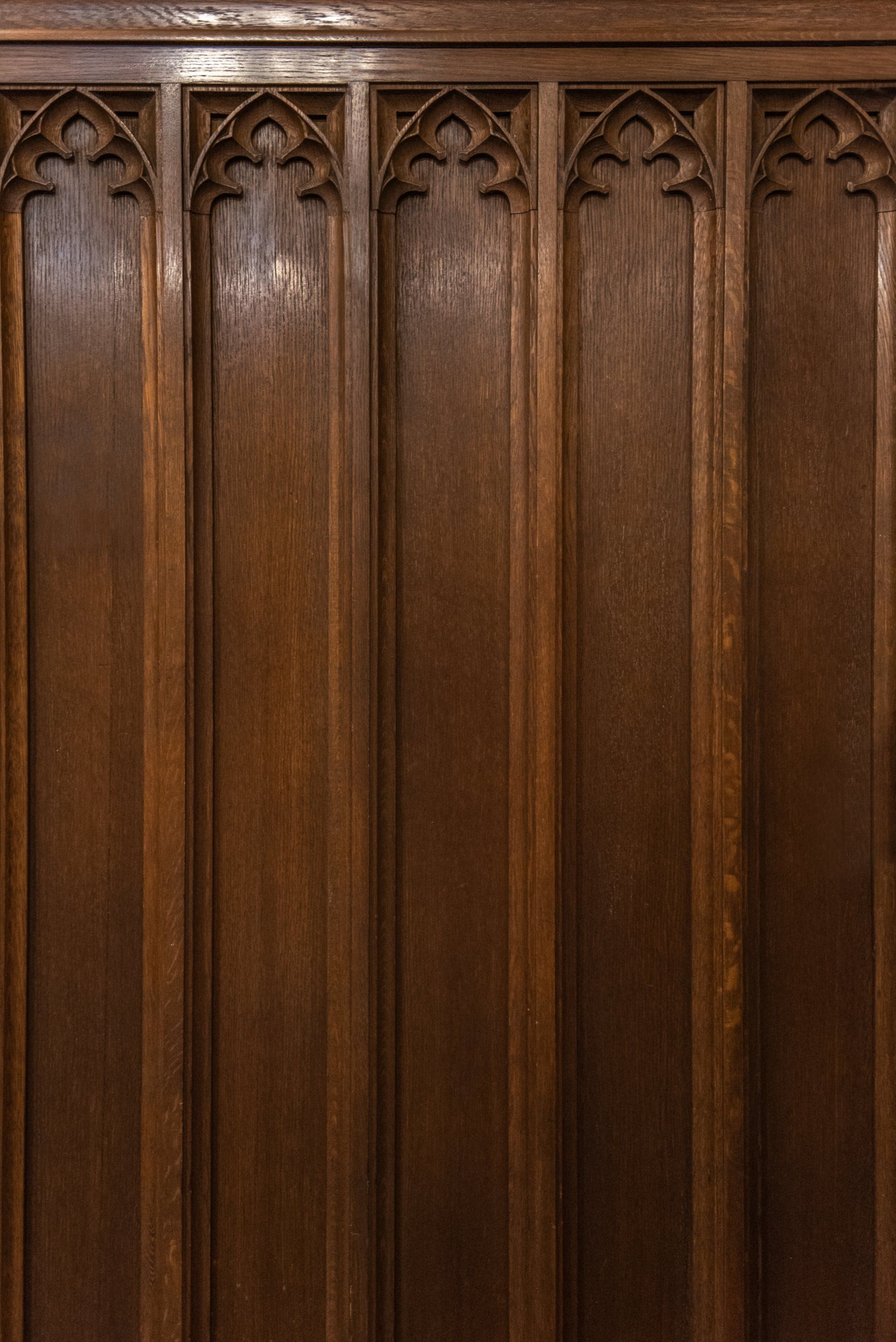 Dark wood paneling with Gothic arch details.