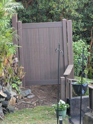 A wooden fence with a water fountain in the backyard.