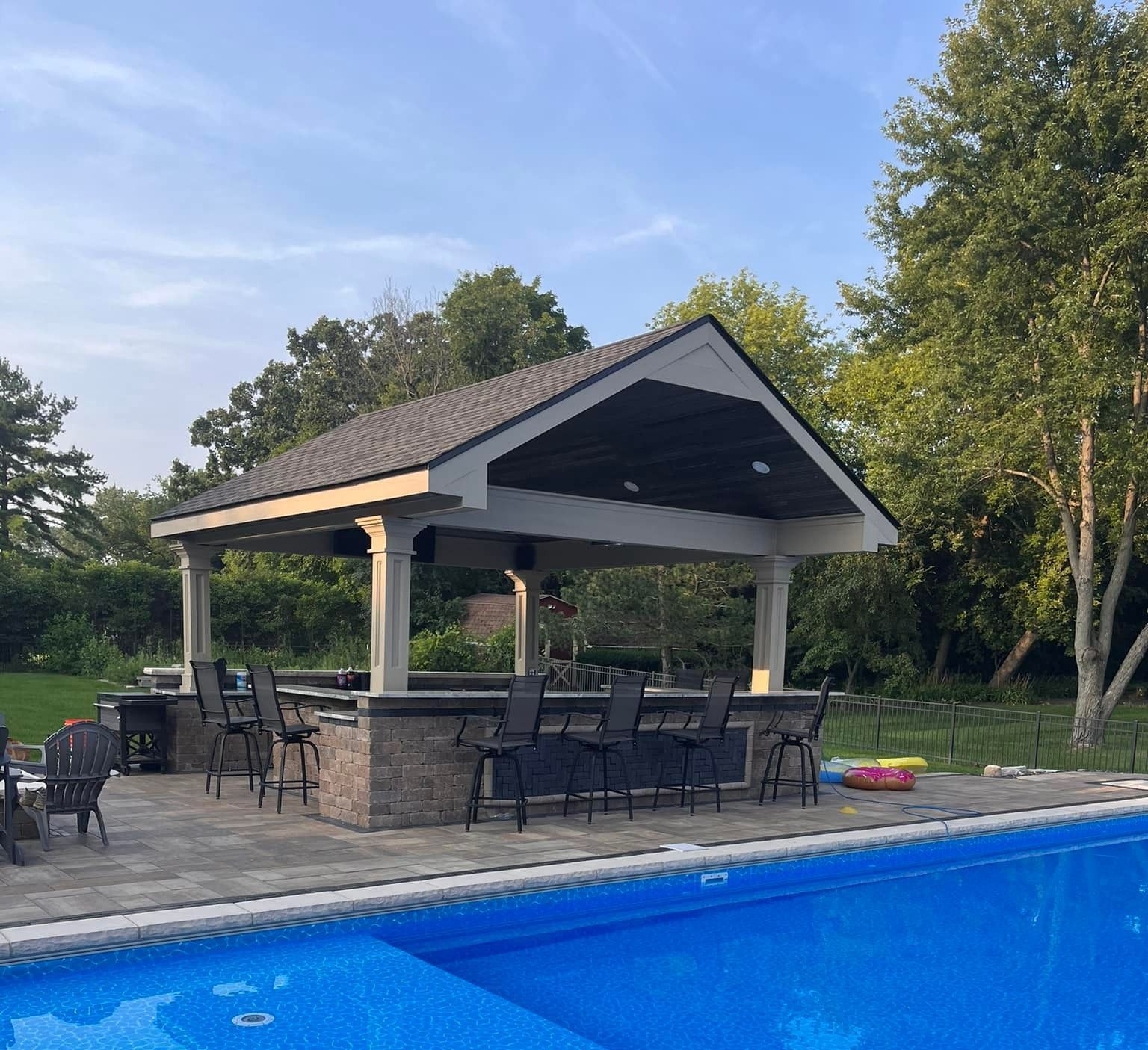 A gazebo is sitting next to a swimming pool