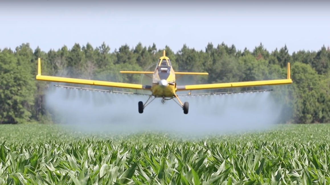 A tractor is spraying fertilizer on a field.