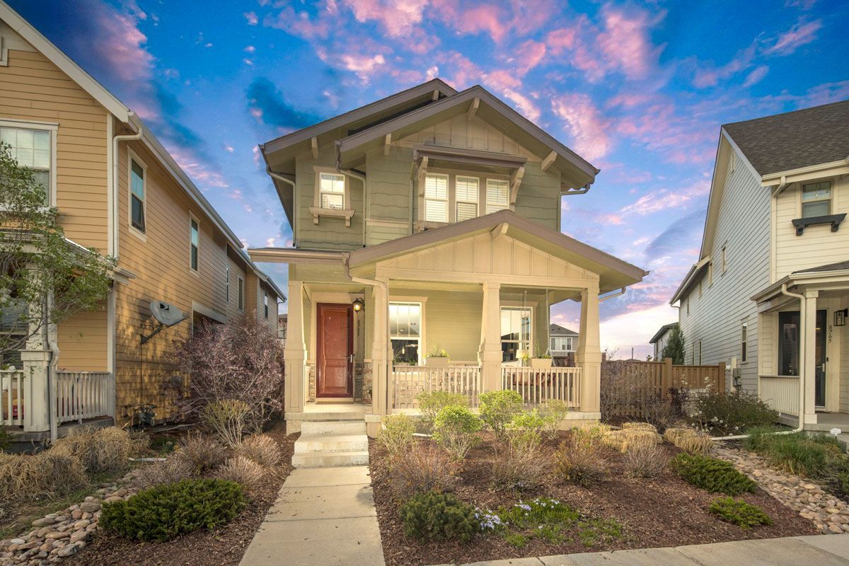 A house with a porch and a sunset in the background