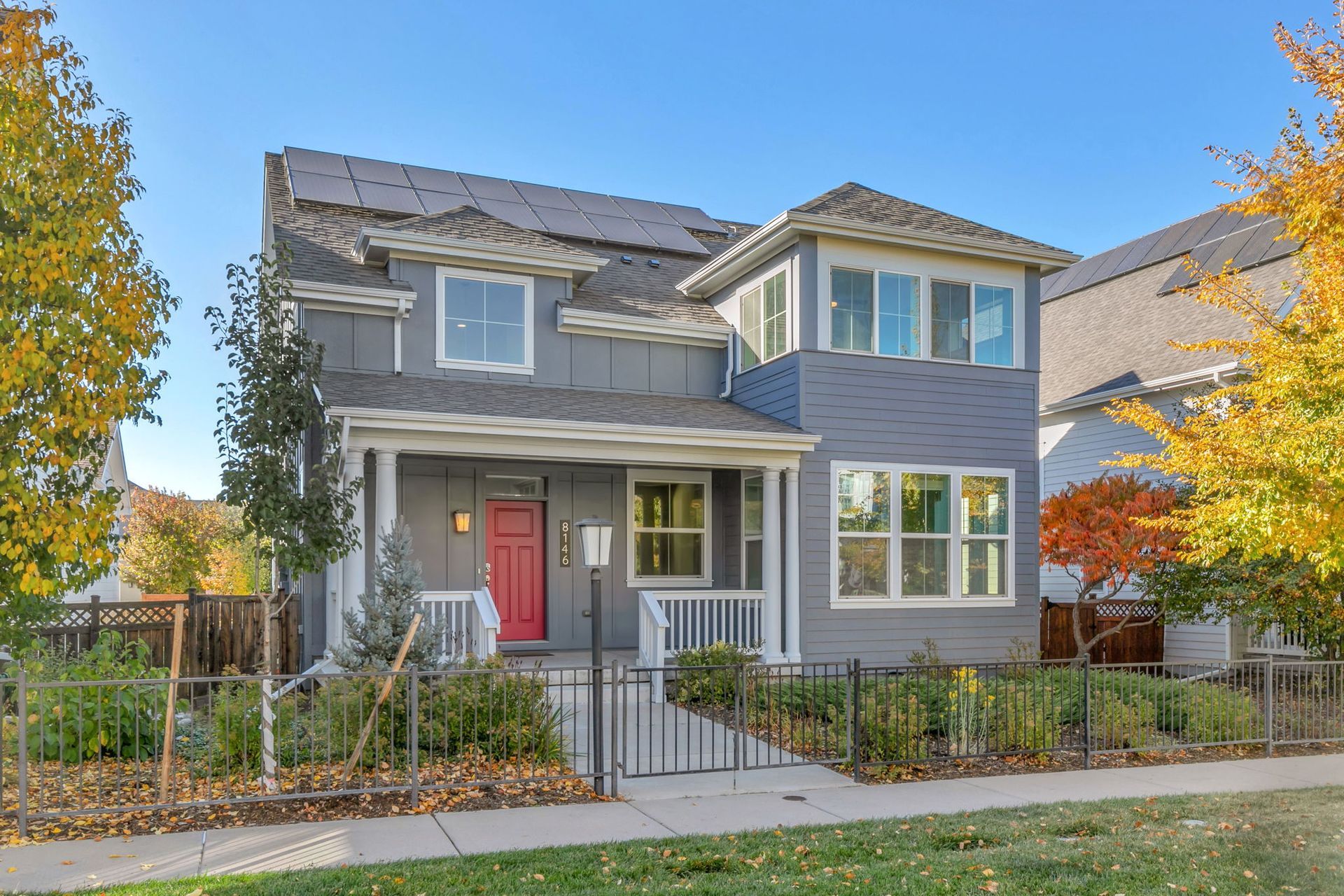 A gray house with a red door and white trim