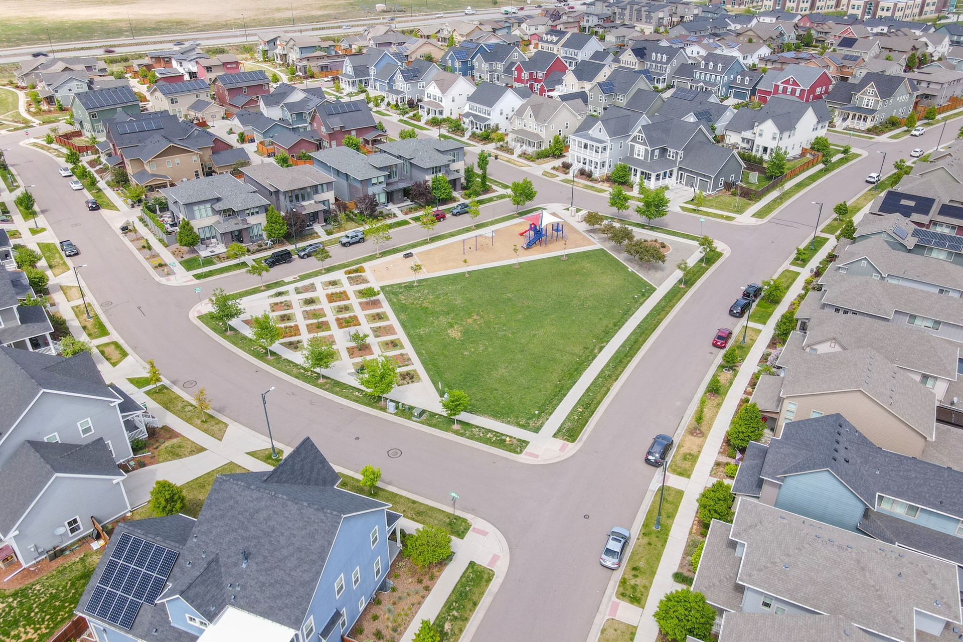 An aerial view of a residential neighborhood with a park in the middle.