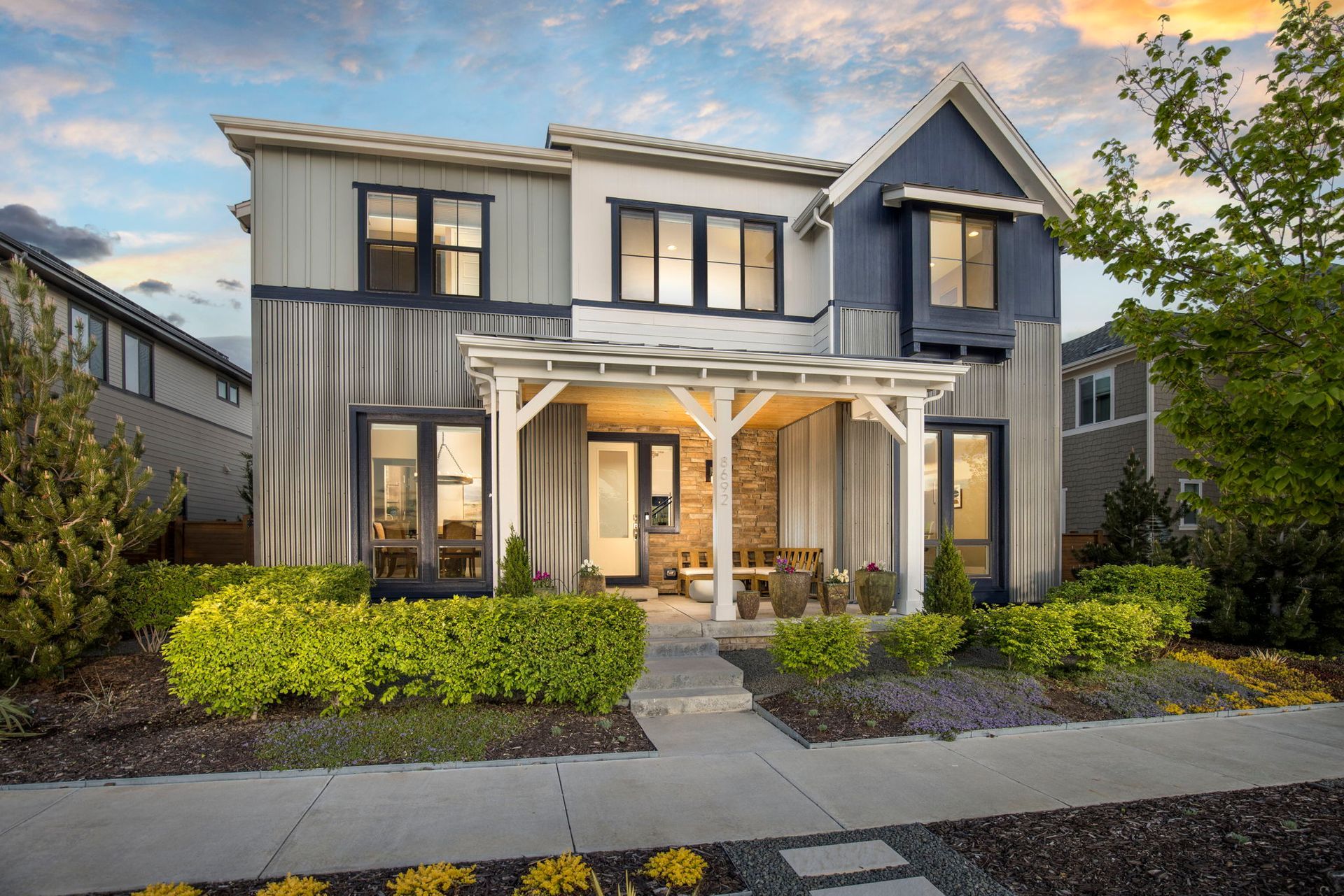 A large white and blue house with a porch and a lot of windows.