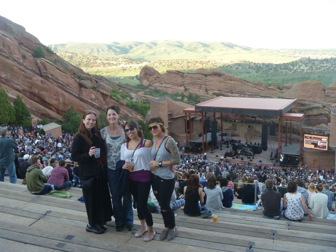 A group of women are posing for a picture in front of a crowd at a concert.