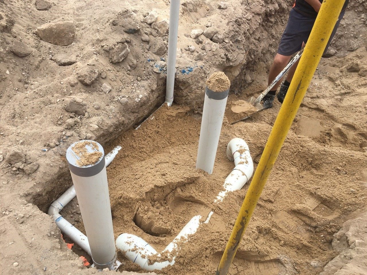 A man is digging a hole in the ground with a shovel.