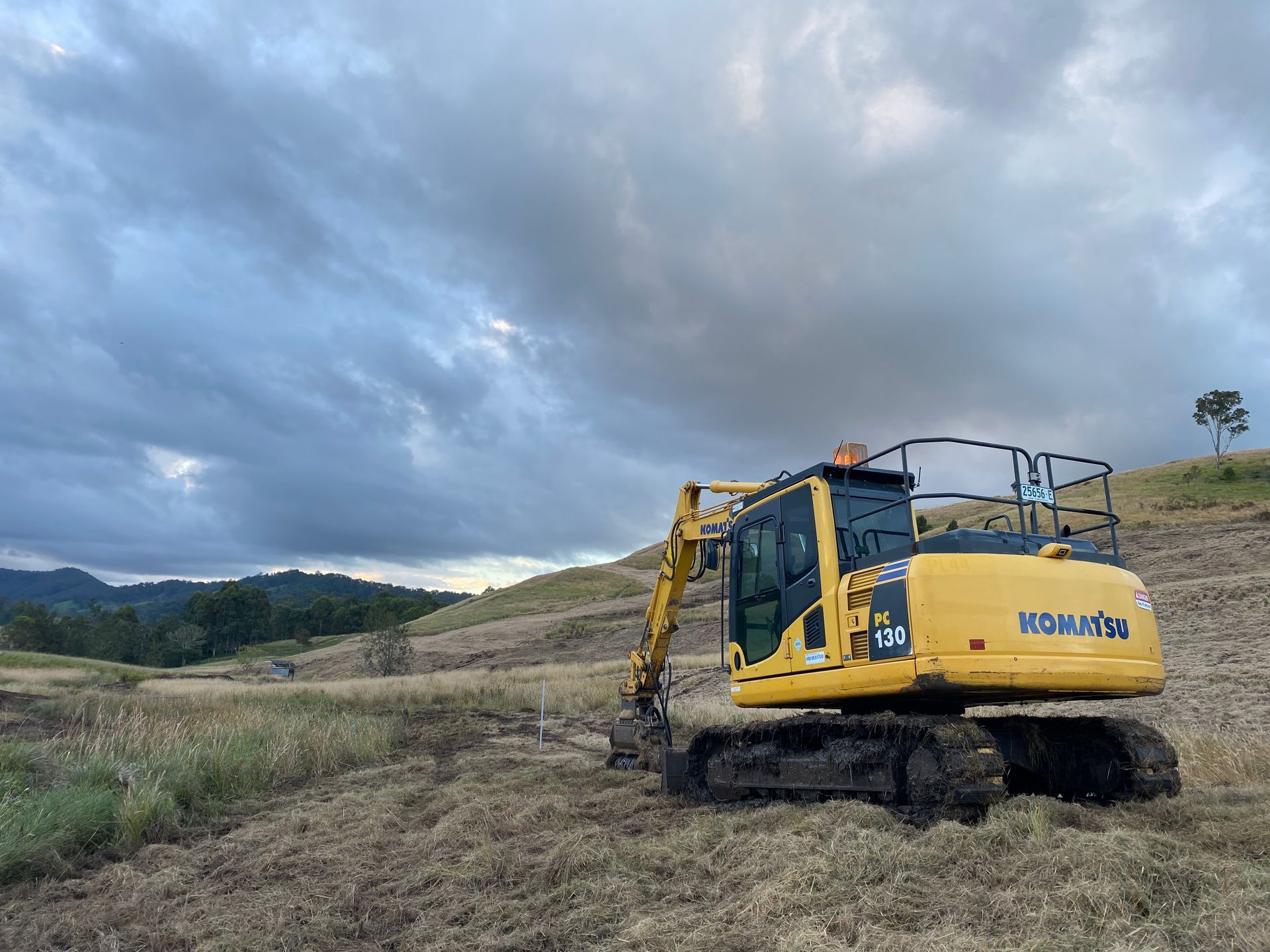 A Yellow Komatsu Excavator on a Hillside — PVM Contracting in Alstonville, NSW
