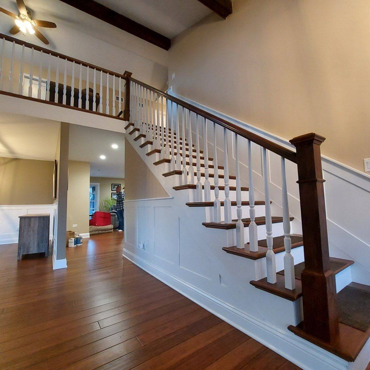 Interior with hardwood floors and a staircase with wooden railings and white spindles.