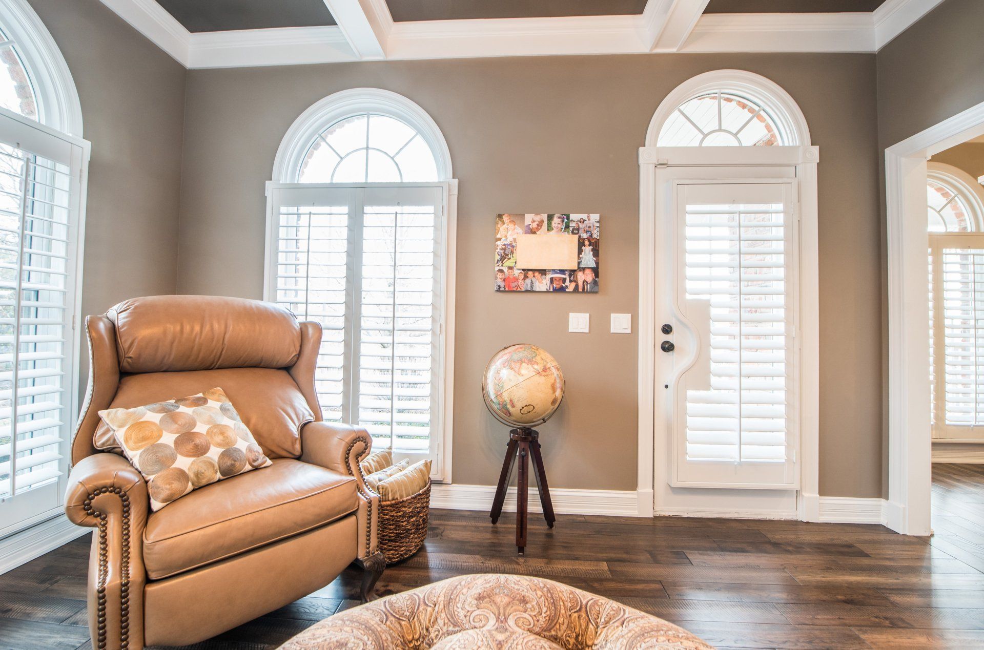 Living room with tan recliner, globe lamp, white shutters, and gray walls
