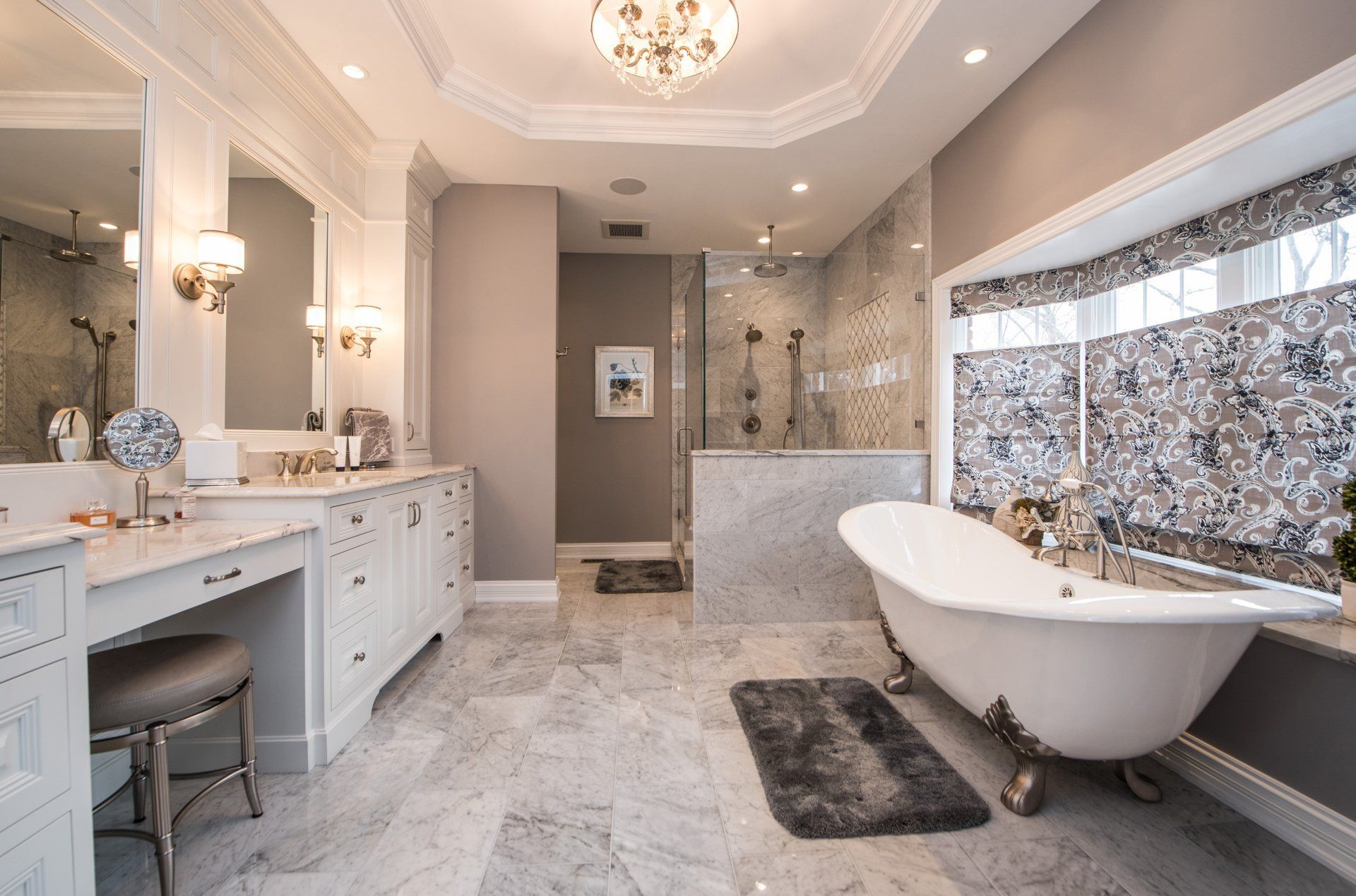 Elegant marble bathroom with double vanity, freestanding tub, and large window