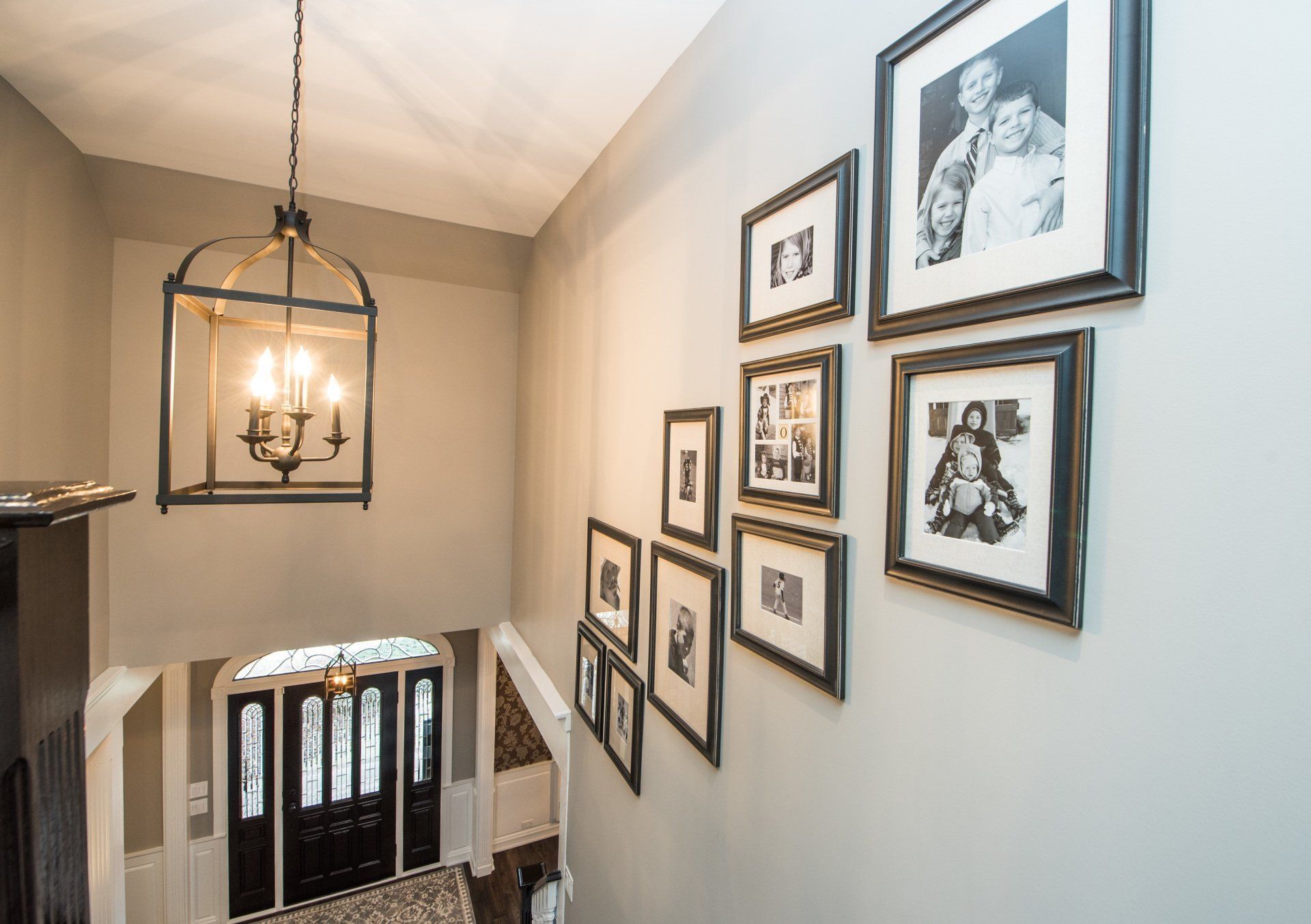 Stairwell wall with framed black-and-white photos and a hanging lantern light