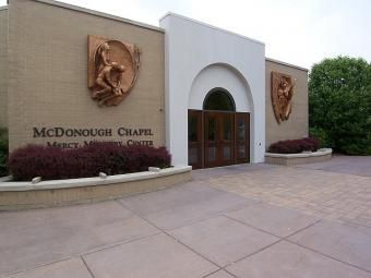 McDonough Chapel entrance with arched doorway, bronze plaques, and a paved courtyard