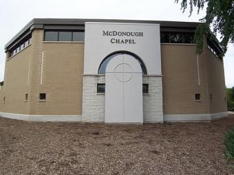 McDonough Chapel building with tan brick walls, white archway, and a stone base
