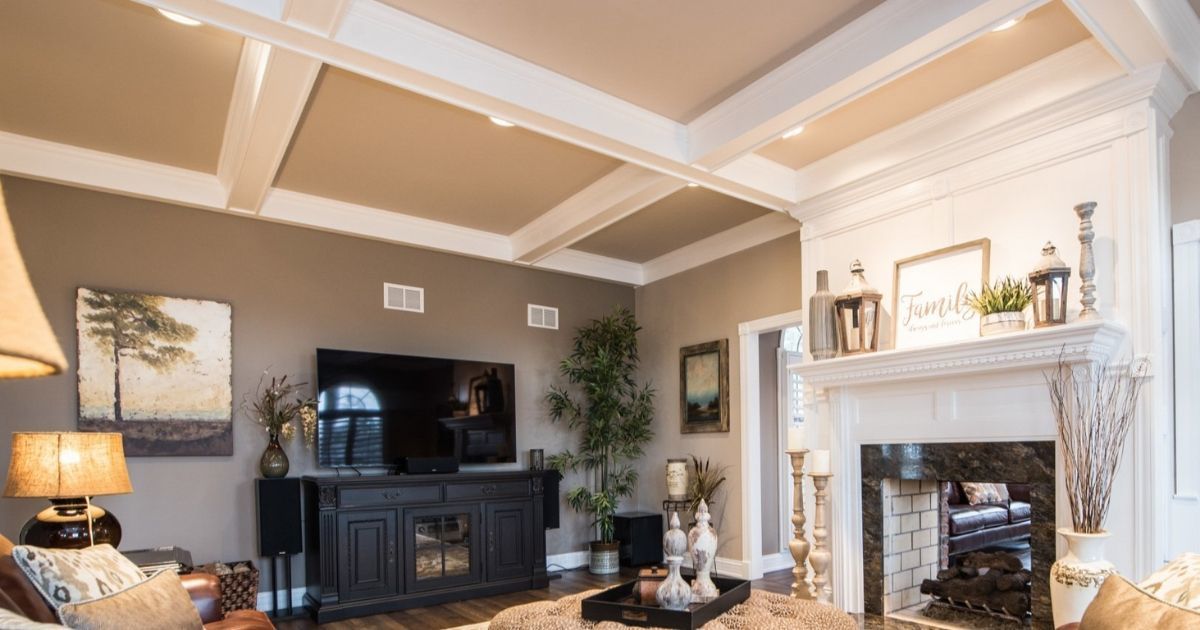 Elegant living room with coffered ceiling, dark TV cabinet, cream fireplace, and warm neutral decor