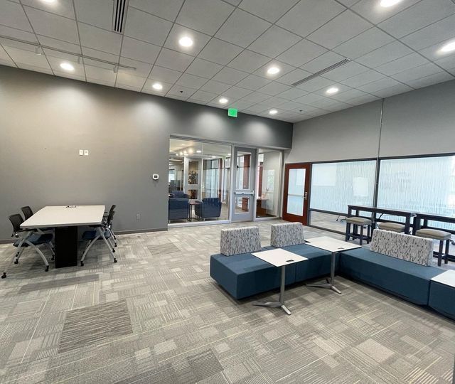 A large room with a table and chairs in it.