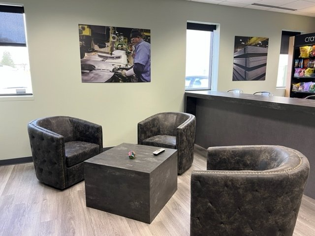 A waiting room with three chairs and a table