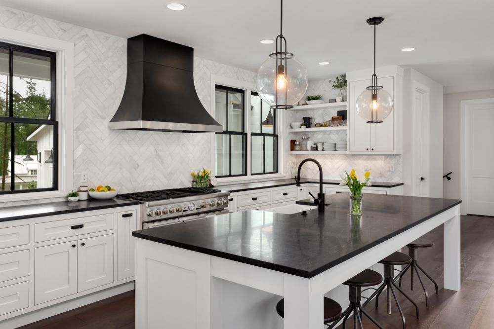 A Kitchen With White Cabinets, Black Counter Tops, And A Large Island — Gold Coast City Plumbing In Helensvale, QLD