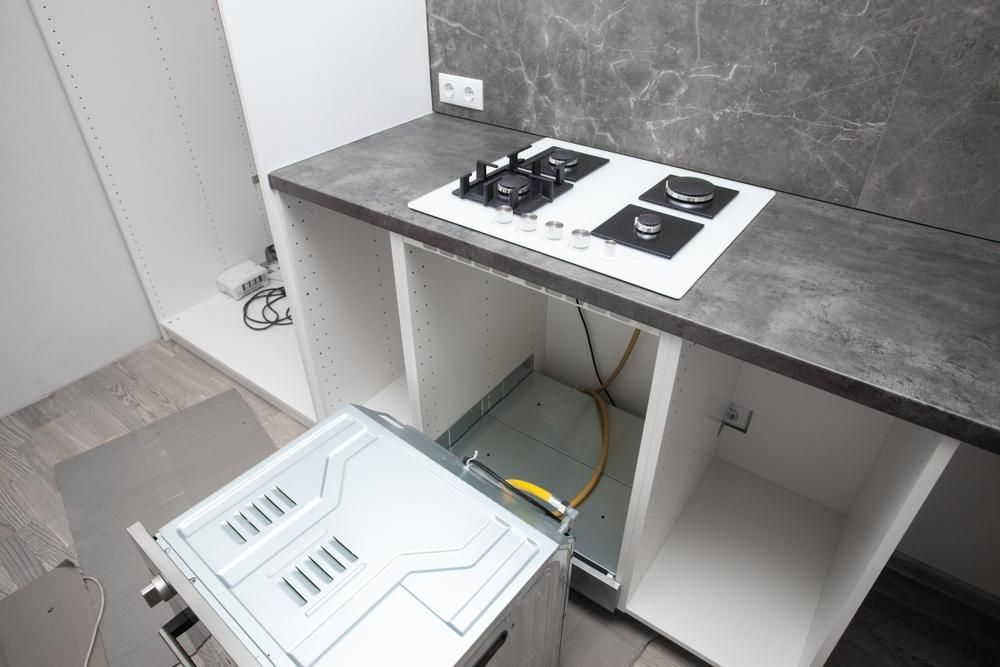 A Kitchen With A Gas Stove And A Microwave — Gold Coast City Plumbing In Helensvale, QLD