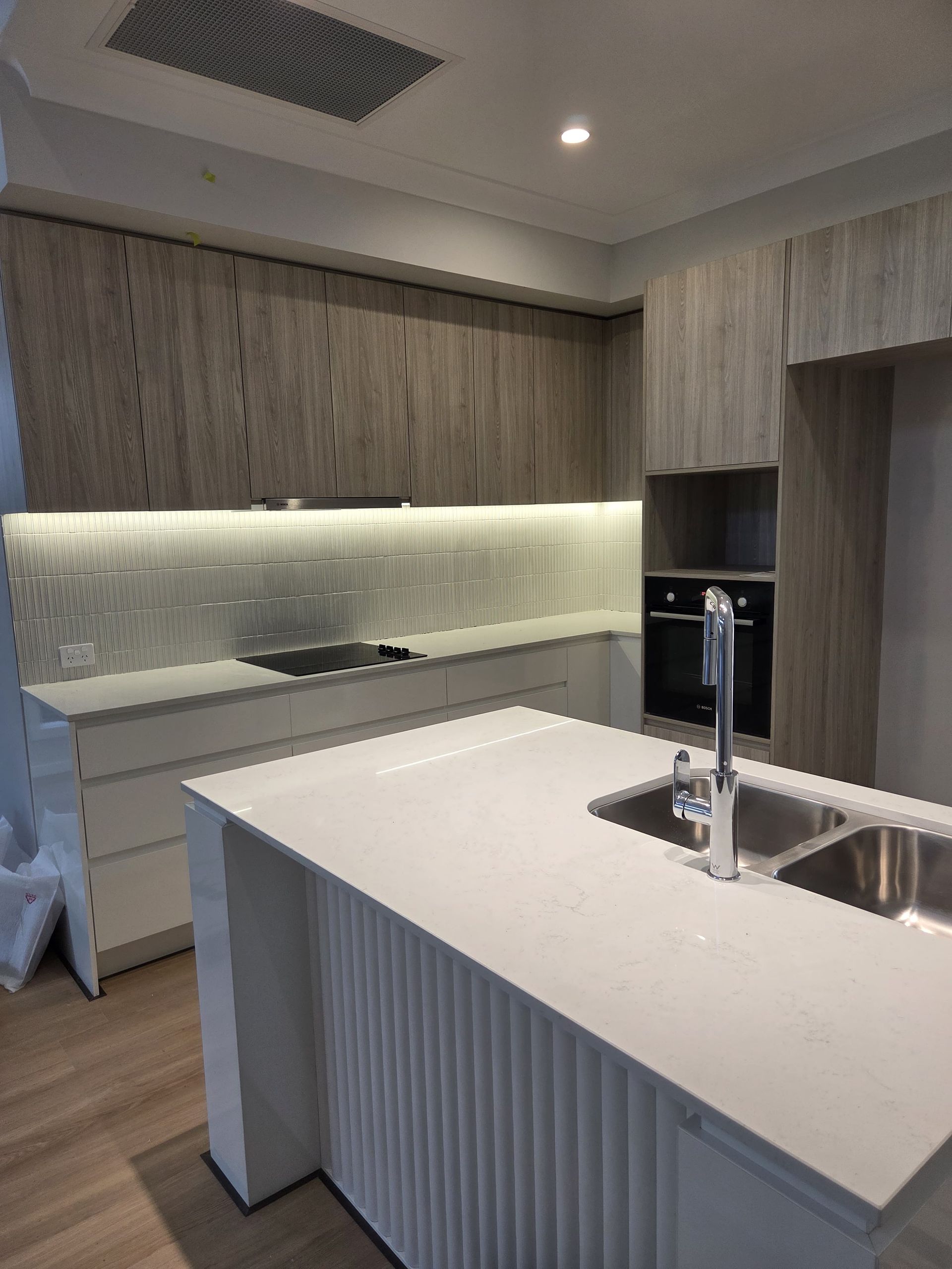 A Modern Kitchen Featuring Light Wood-toned Upper Cabinets — Better Stone in Caloundra West, QLD