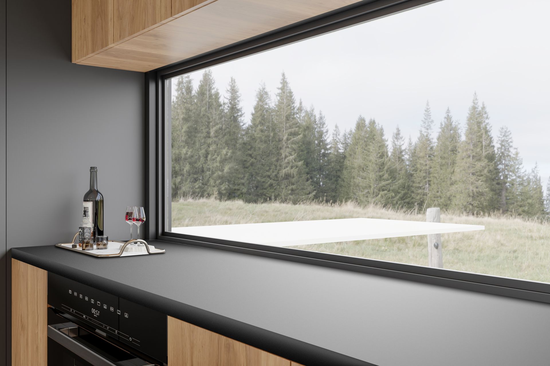 Kitchen with a view: black countertop, oven, wooden cabinets, window overlooking a forest and a table.