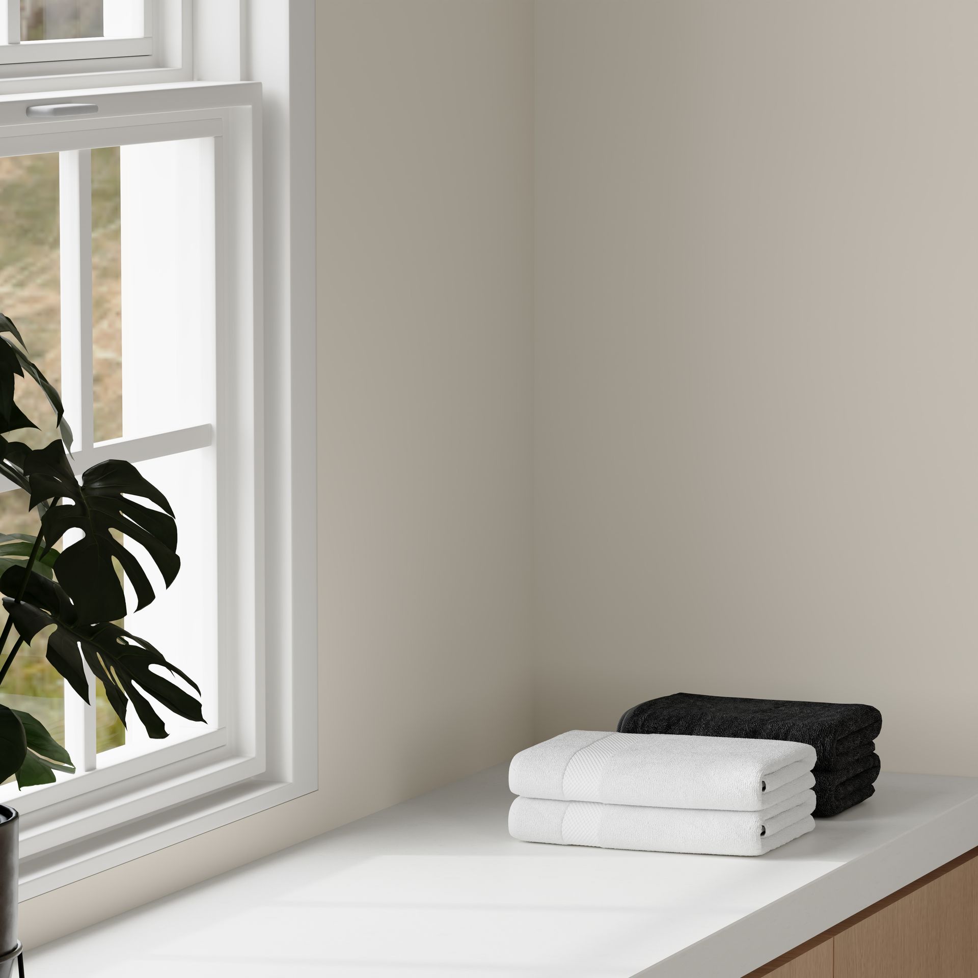 A Houseplant Sits Next to a Window With White and Dark Gray Folded Towels — Better Stone in Caloundra West, QLD