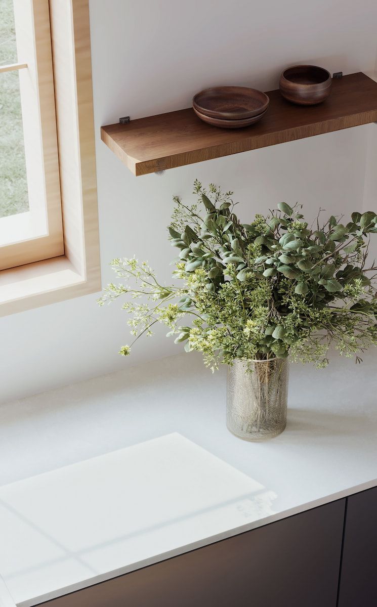 A Vase of Flowers Is Sitting on a Counter Next to a Window — Better Stone in Caloundra West, QLD