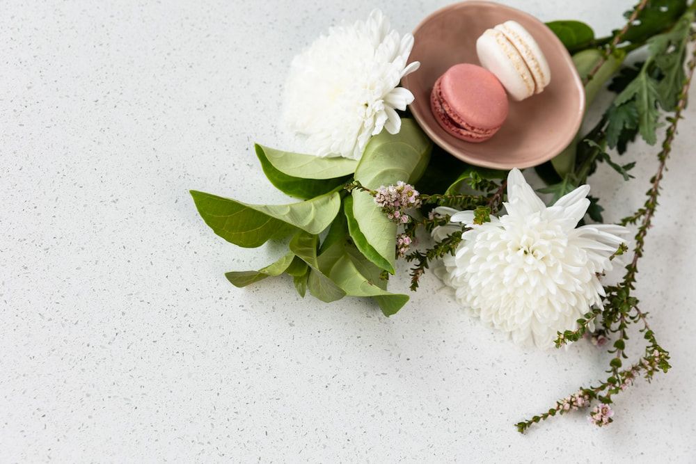 A Bowl of Macarons and Flowers on a White Surface — Better Stone in Caloundra West, QLD
