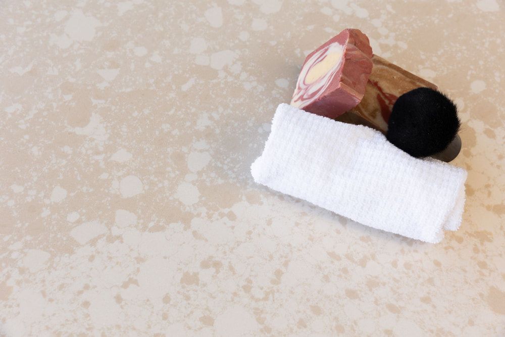 A White Towel is Laying on a Counter Next to a Piece of Soap — Better Stone in Caloundra West, QLD