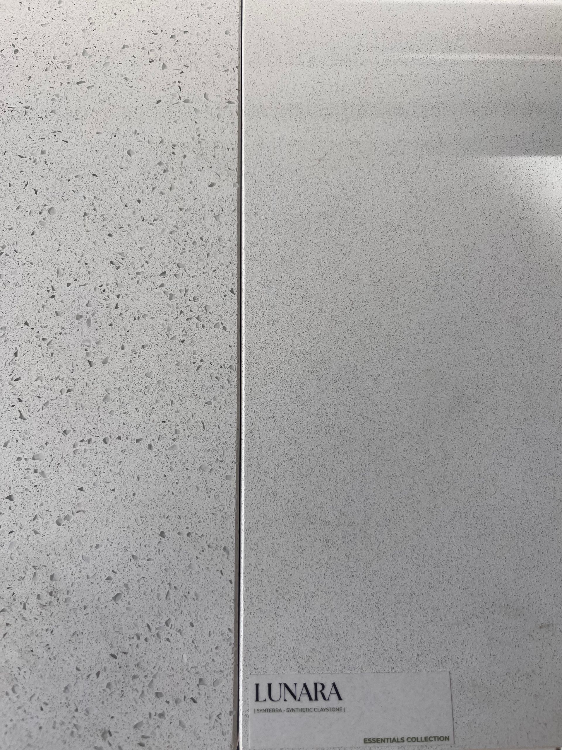 Two light gray speckled tiles side by side with the word 