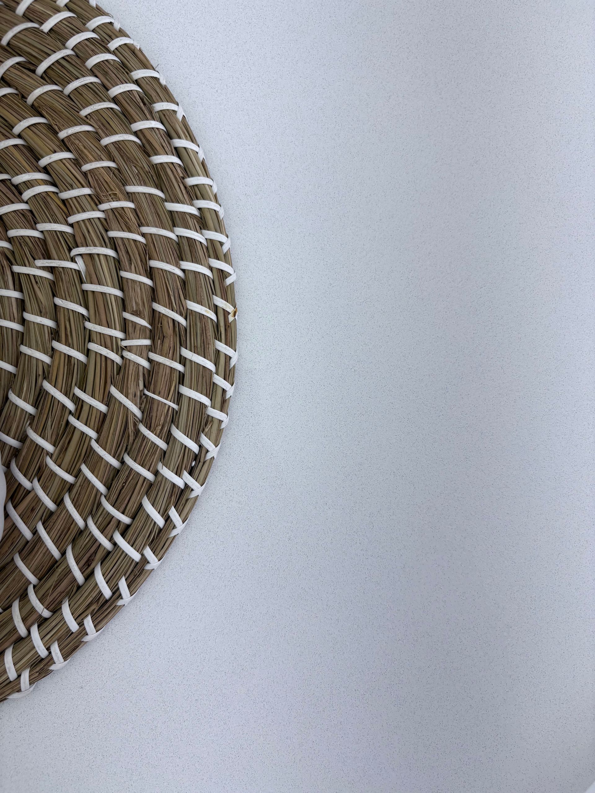Brown and white woven coaster on a white surface.