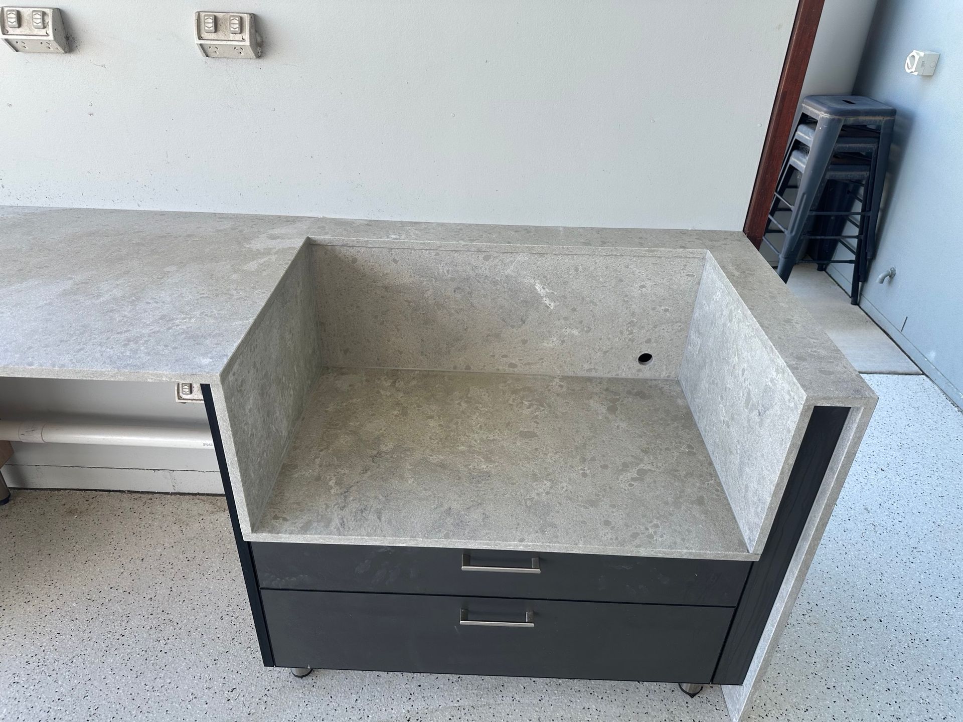 Outdoor concrete countertop with a built-in sink and two drawers.