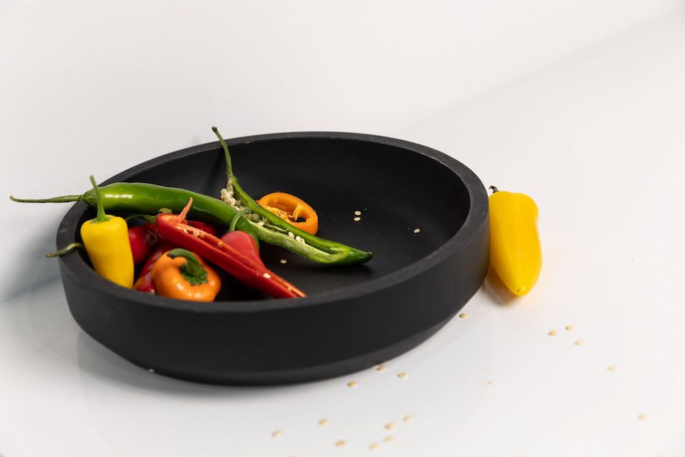 A Black Bowl Filled With Peppers on a White Surface — Better Stone in Caloundra West, QLD
