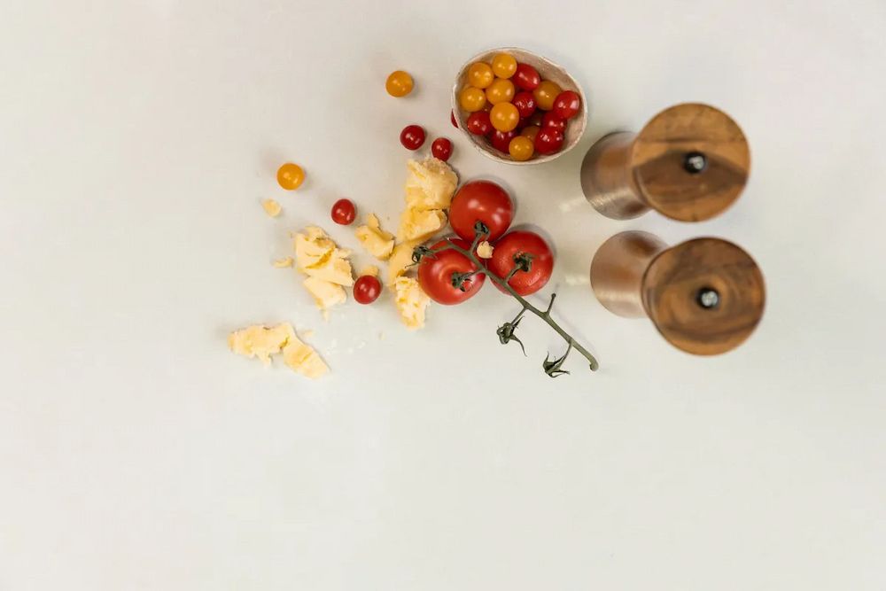 A Table Topped With Tomatoes, Cheese, and Salt and Pepper Shakers — Better Stone in Caloundra West, QLD