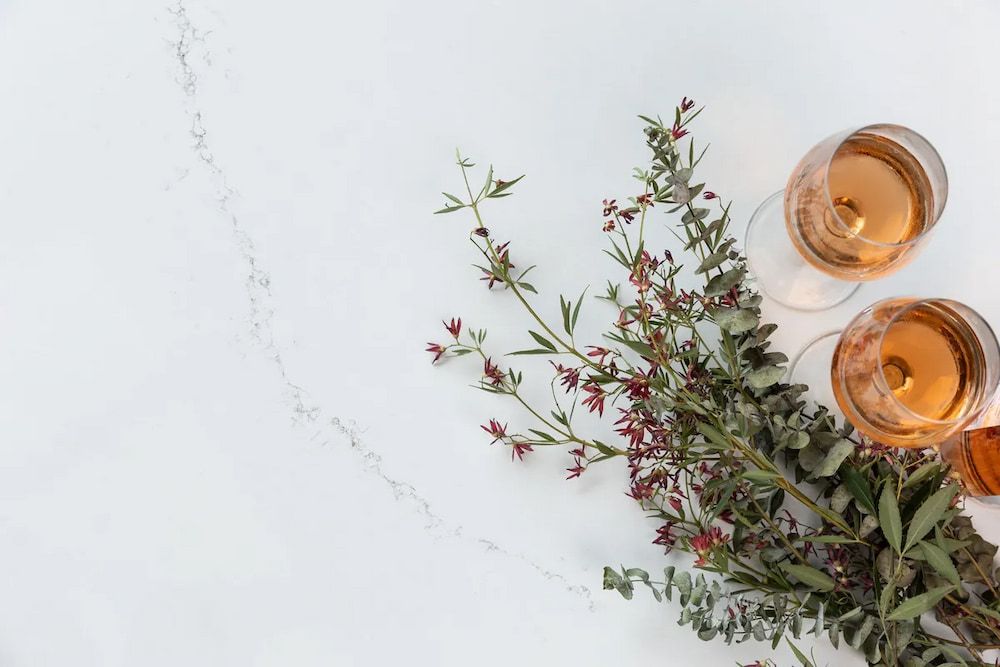 There Are Two Glasses of Wine and Flowers on the Table — Better Stone in Caloundra West, QLD